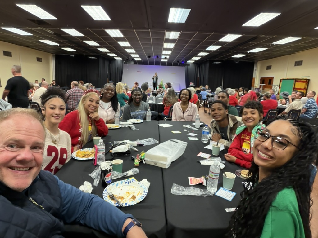Christ Fellowship Tampa college students and young adults gathered around a table and smiling together